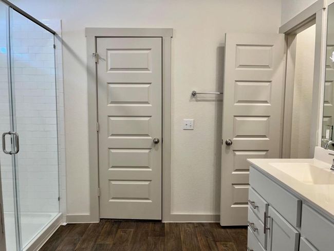 Bathroom featuring a stall shower, vanity, wood finished floors, and baseboards | Image 15