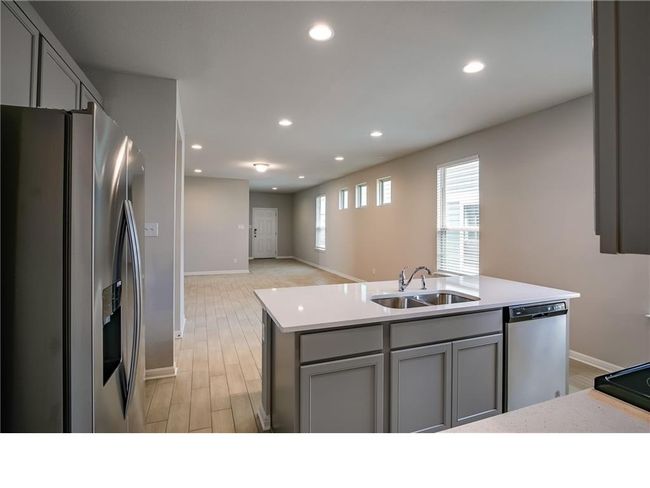 Kitchen featuring appliances with stainless steel finishes, gray cabinets, light countertops, recessed lighting, and light wood-type flooring | Image 11