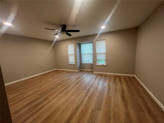 Unfurnished room with wood finished floors, baseboards, and ceiling fan | Image 12
