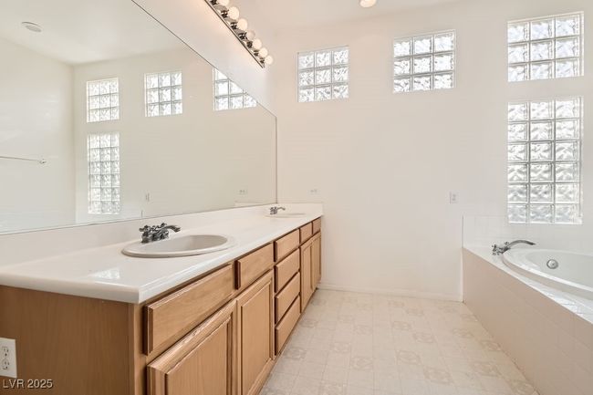 Bathroom with a sink, baseboards, double vanity, and a garden tub | Image 18