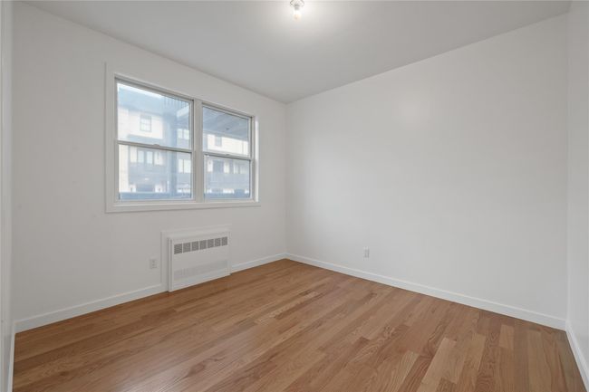 Spare room featuring radiator heating unit, light wood finished floors, and baseboards | Image 29
