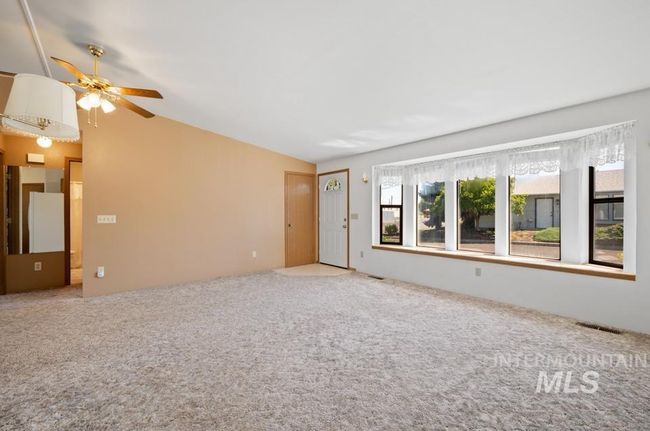 Unfurnished living room with lofted ceiling, a ceiling fan, and carpet | Image 21