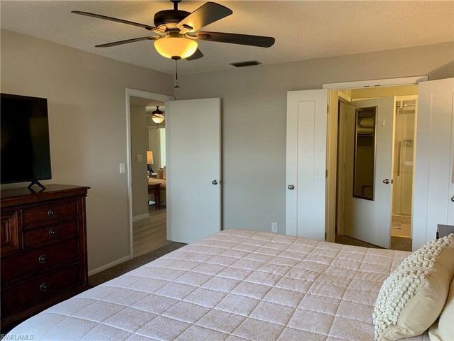 Carpeted bedroom featuring a ceiling fan and connected bathroom | Image 12