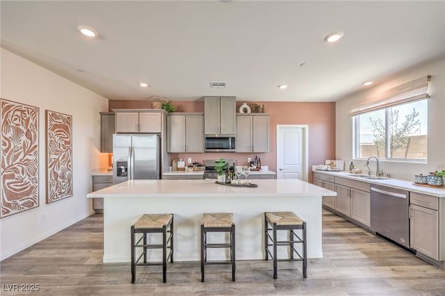 Kitchen featuring appliances with stainless steel finishes, a sink, gray cabinetry, a kitchen breakfast bar, and recessed lighting. Photo is representational only; actual home finishes may vary. | Image 13