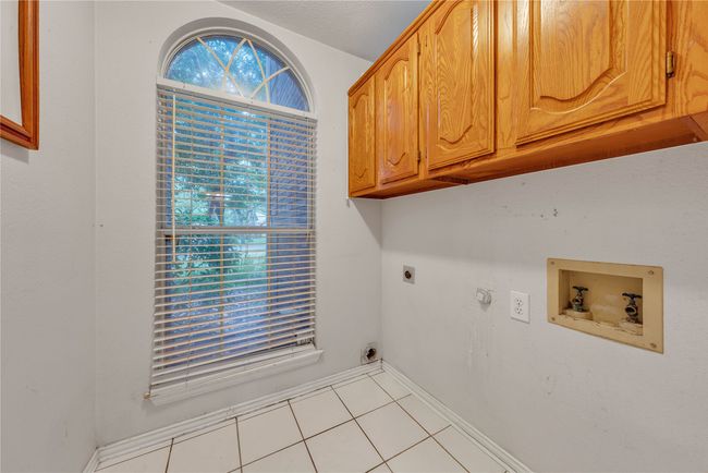 Laundry room featuring hookup for an electric dryer, hookup for a washing machine, cabinet space, and tile patterned flooring | Image 13