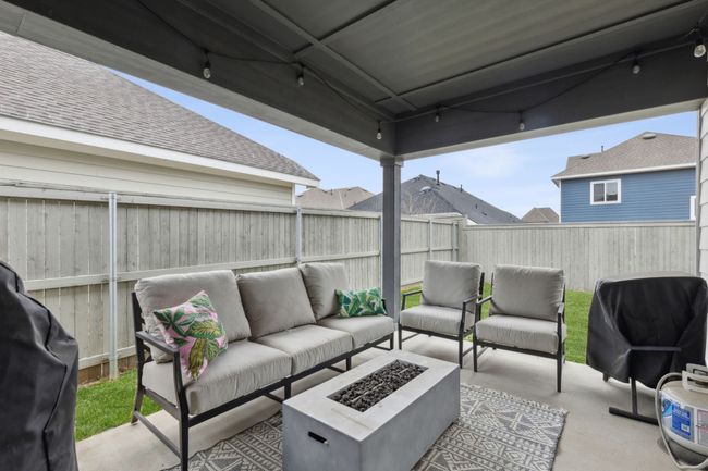 View of patio with an outdoor living space with a fire pit, a fenced backyard, and area for grilling | Image 27