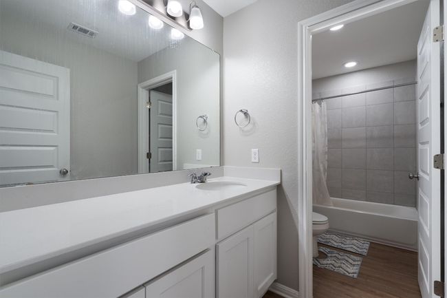 Full bathroom featuring vanity, wood finished floors, shower / tub combo with curtain, and recessed lighting | Image 24