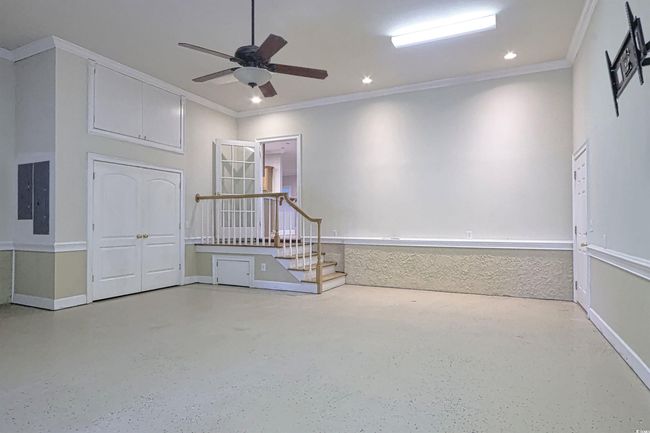 Unfurnished room with crown molding, ceiling fan, stairway, recessed lighting, and speckle patterned floor | Image 20