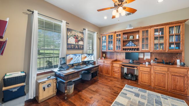 Home office featuring dark wood finished floors, recessed lighting, built in study area, and a ceiling fan | Image 4