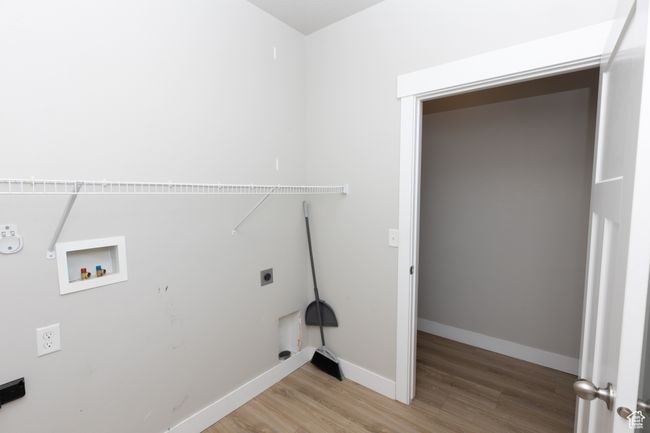 Washroom with electric dryer hookup, light wood-type flooring, gas dryer hookup, washer hookup, and baseboards | Image 23
