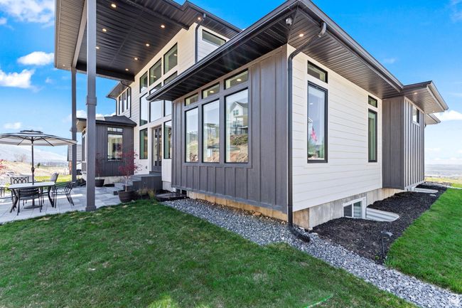 View of side of home with board and batten siding, a patio, and a yard | Image 70