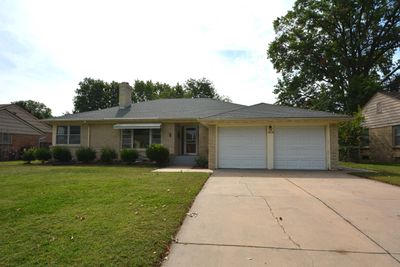 Ranch-style house featuring a front lawn and a garage | Image 1