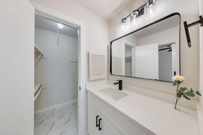 Primary sink with vanity space and see walk in closet. | Image 22