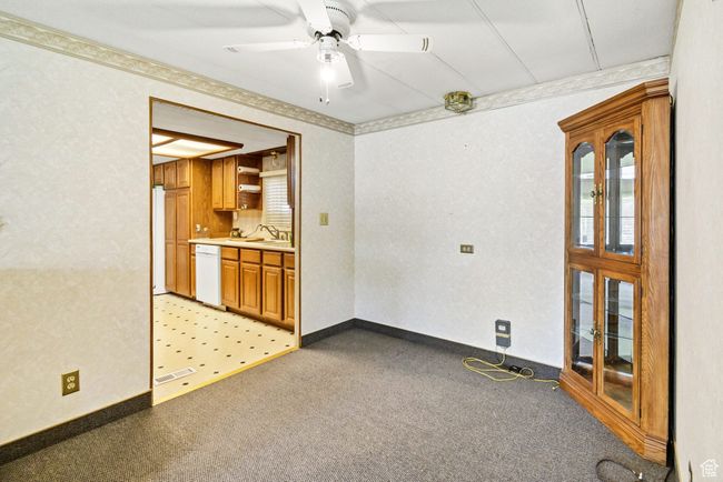 Empty room with light colored carpet, a sink, and a ceiling fan | Image 13