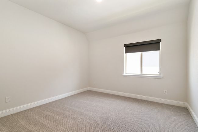 Carpeted empty room featuring baseboards and vaulted ceiling | Image 26