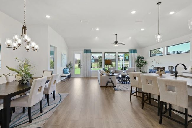 Dining space with vaulted ceiling, healthy amount of natural light, light wood finished floors, recessed lighting, and ceiling fan | Image 6