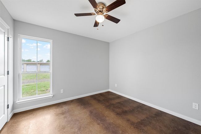 Spare room featuring baseboards, ceiling fan, and concrete floors | Image 7