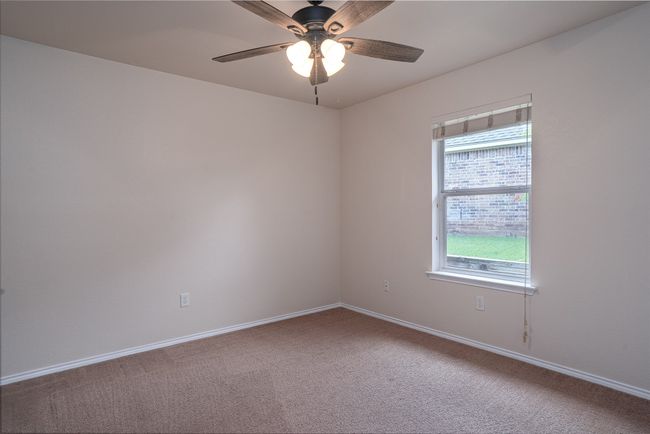 Spare bedroom featuring a ceiling fan | Image 25