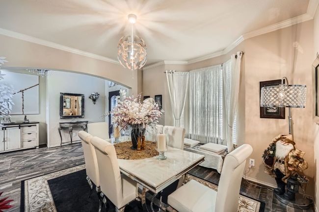 Dining area featuring arched walkways, ornamental molding, healthy amount of natural light, and a chandelier | Image 11