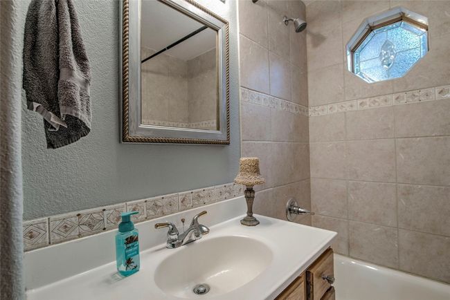 Bathroom featuring shower combination, vanity, and a textured wall | Image 21
