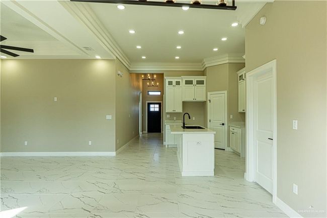 Kitchen featuring a ceiling fan, marble finish floor, baseboards, and an island with sink | Image 28