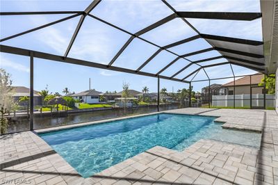 View of swimming pool featuring a patio and glass enclosure | Image 1