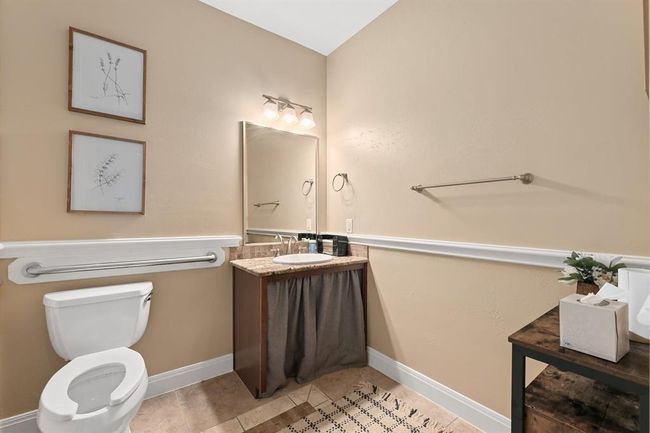 Bathroom featuring baseboards, toilet, tile patterned flooring, and vanity | Image 13