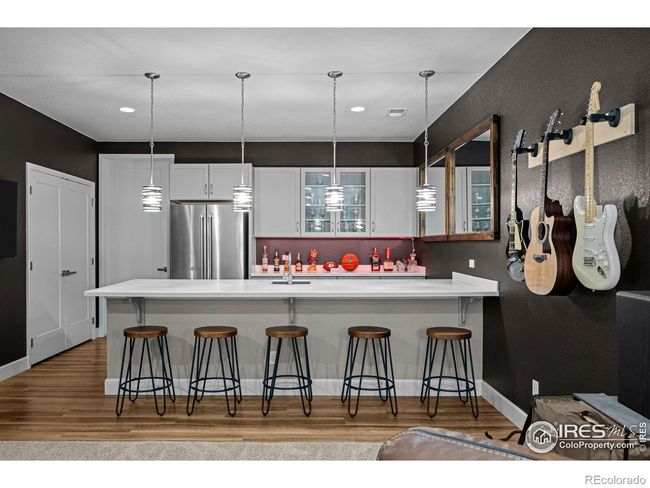 Basement features a wet bar with counter-style seating | Image 22