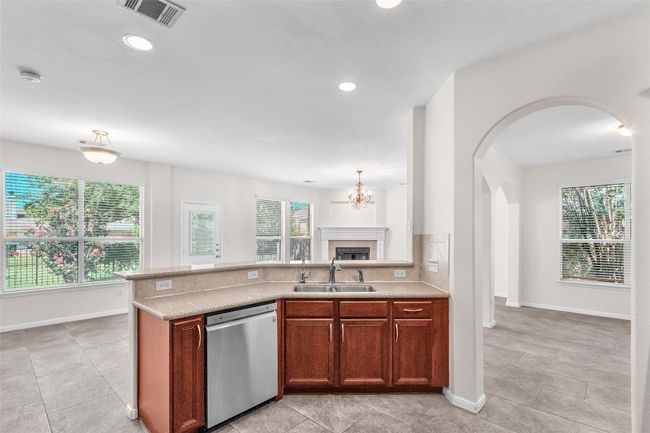 Kitchen with dishwasher, recessed lighting, hanging light fixtures, a chandelier, and a fireplace | Image 11