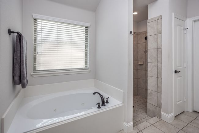 Full bathroom featuring a tub with jets, tiled shower, and tile patterned flooring | Image 26