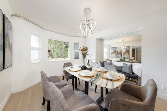 Dining space with wood finished floors, a chandelier, crown molding, and plenty of natural light | Image 12