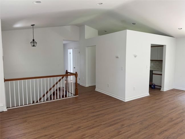 Spare room featuring dark wood-style flooring, vaulted ceiling, and recessed lighting | Image 6