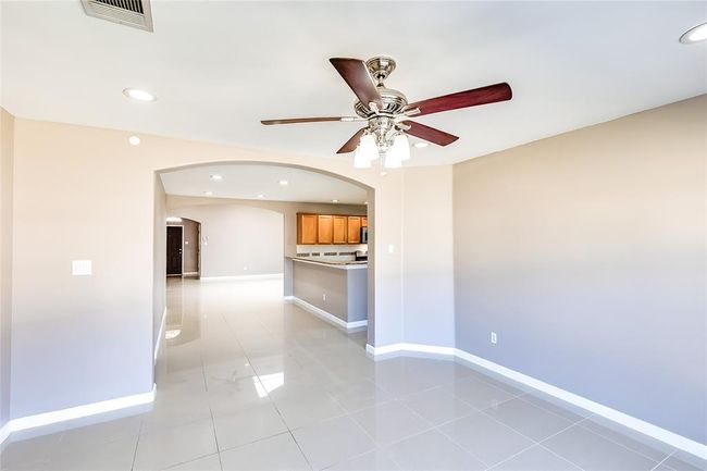 Unfurnished living room with arched walkways, a ceiling fan, recessed lighting, and light tile patterned floors | Image 14