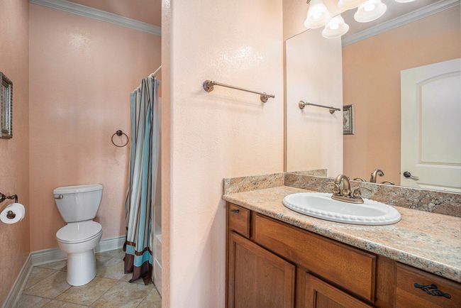 Another full bathroom, found at the top of the stairs, offers ideal functionality, serving as a convenient amenity for the adjacent secondary bedrooms. | Image 28