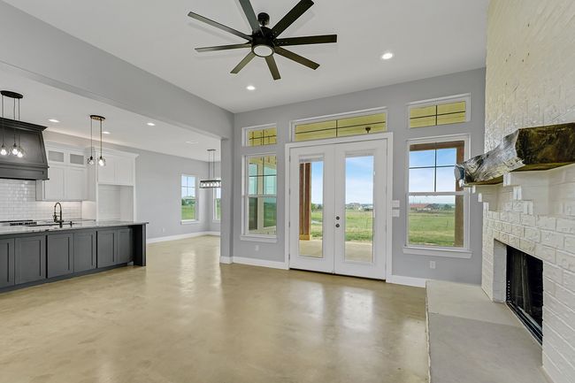 Unfurnished living room with a fireplace, baseboards, concrete floors, recessed lighting, and ceiling fan | Image 7