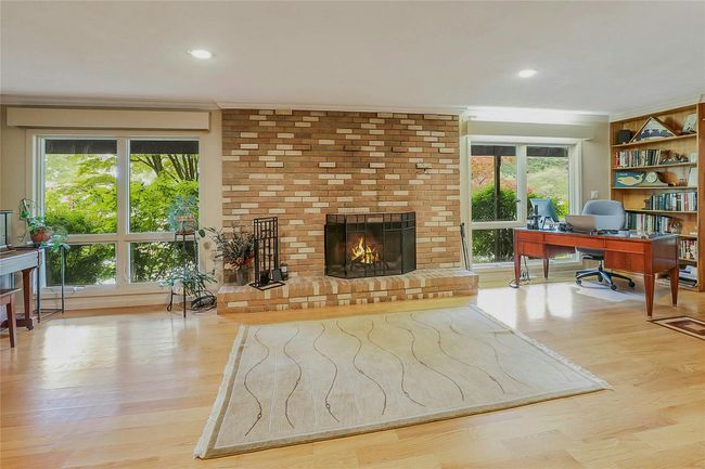 Living area with a desk, a brick fireplace, ornamental molding, wood finished floors, and recessed lighting | Image 5