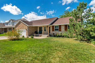 Ranch-style home with a garage and a front lawn | Image 1