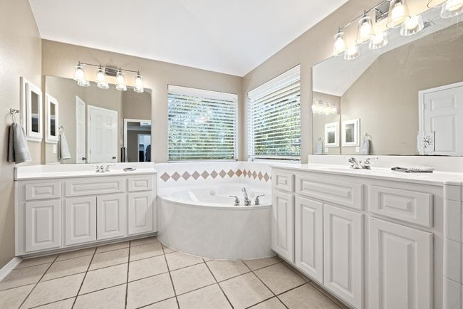 The ensuite bath offers everyday comfort with dual vanities, a jetted tub, a separate shower, and a layout that gives each feature its own sense of space | Image 22