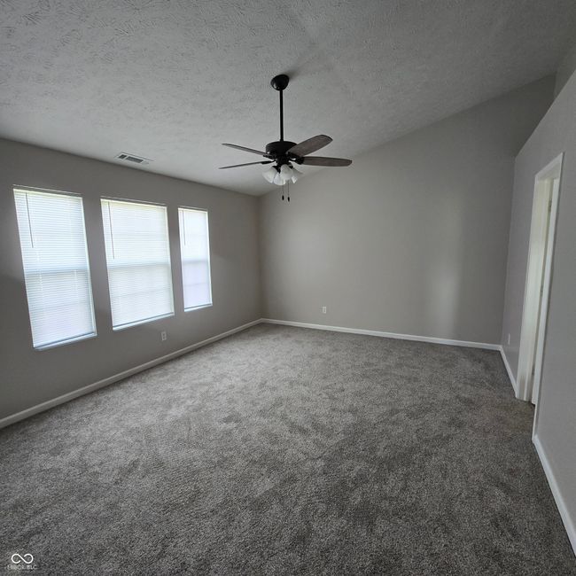 Looking into the primary bedroom -- vaulted ceiling--new ceiling fan--new carpet... | Image 6