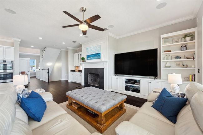 View of the primary living area, showcasing the luxury custom DuraSupreme cabinets, fireplace mantel and trim, built-ins and bookcase. | Image 32