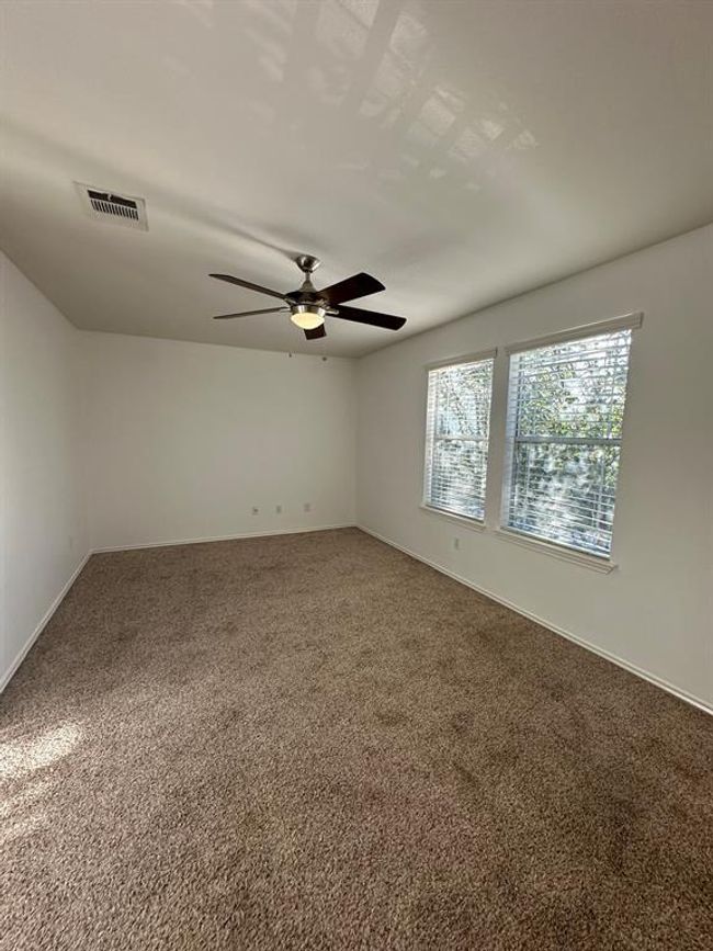 Carpeted empty room featuring ceiling fan and baseboards | Image 7