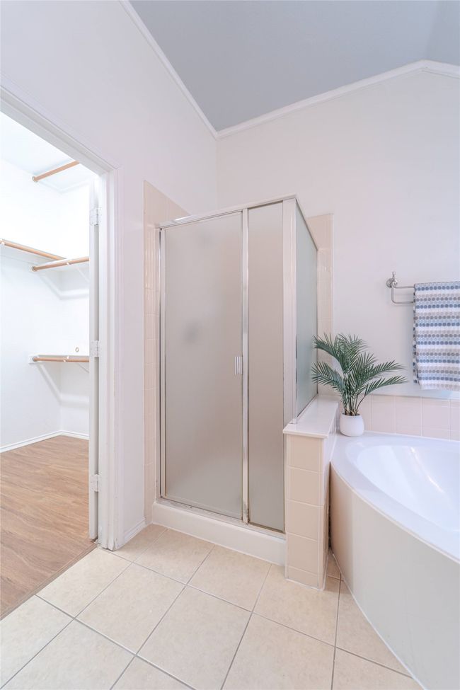 Full bathroom featuring a shower stall, a walk in closet, a garden tub, crown molding, and tile patterned floors | Image 29