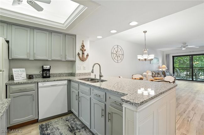 Kitchen featuring dishwasher, ceiling fan, a peninsula, open floor plan, and light wood-type flooring | Image 14