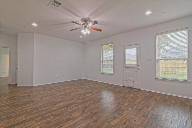 Empty room featuring dark wood-type flooring, ceiling fan, and recessed lighting | Image 9