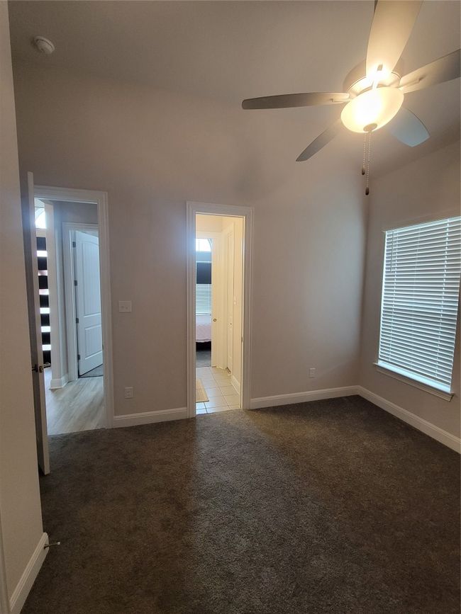 Carpeted empty room featuring baseboards and ceiling fan | Image 8