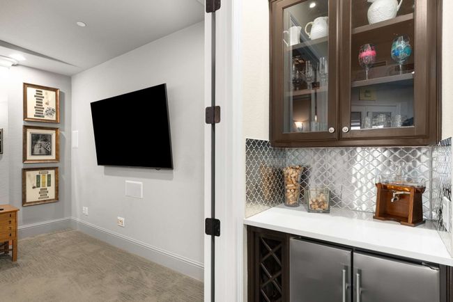 Dry bar with refrigerator leading to media room. | Image 29