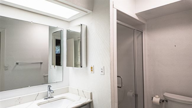 Bathroom with toilet, a stall shower, and vanity | Image 30