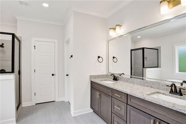 Bathroom with visible vents, a sink, baseboards, and a stall shower | Image 4