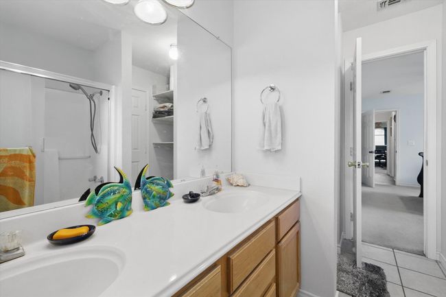 Full bathroom with a shower stall, tile patterned flooring, double vanity, and a sink | Image 23