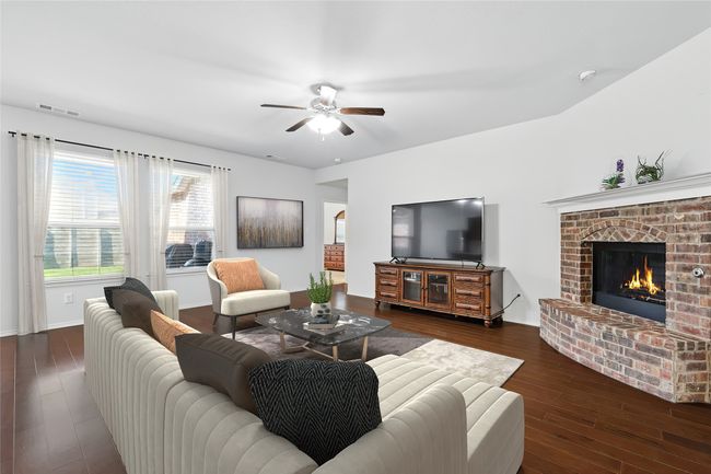 Living area with visible vents, a fireplace, dark wood-style floors, and ceiling fan | Image 21